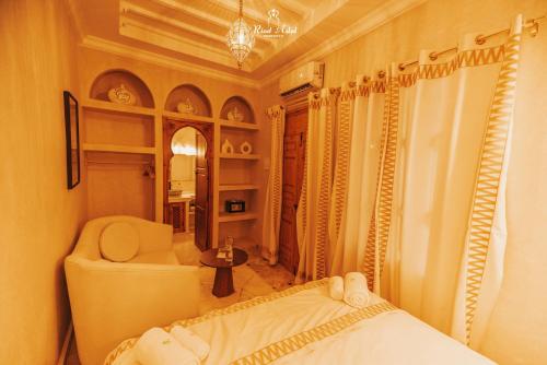 a bedroom with a bed and a chair and a mirror at Riad Aslal in Marrakech