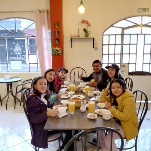a group of people sitting at a table eating food at Hotel Amazonia y sol in Baños