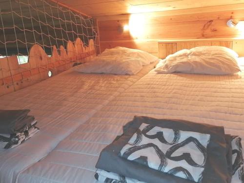- 2 lits jumeaux dans une chambre dotée de murs en bois dans l'établissement JOLIE CABANE BOIS SOUS LES CHENES Hourtin bourg, à Hourtin