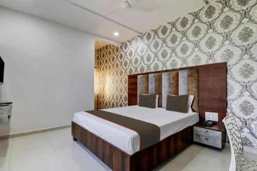 a bedroom with a bed and a wall at Chandana green view resort Hampi in Gangāwati