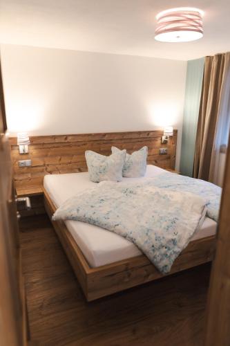 a bedroom with a bed with a wooden headboard and pillows at Garni Stefani in Vent