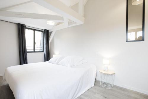 a white bedroom with a white bed and a window at Le Trèfle à Quatre Feuilles in Siorac-en-Périgord