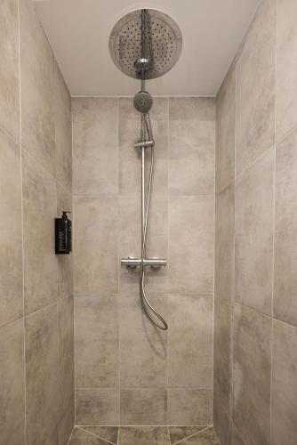 a shower with a shower head in a bathroom at Le Trèfle à Quatre Feuilles in Siorac-en-Périgord