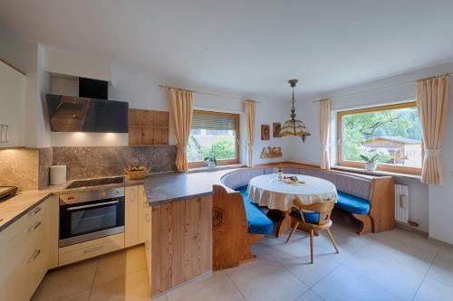 a kitchen with a table and a dining room at Residence Obermoarhof - Family Apartments with Pool & Playground in Vandoies