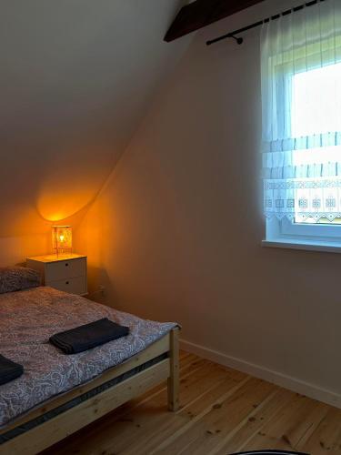 a bedroom with a bed and a window at Letnia Ostoja Wieprz nad Jeziorakiem in Zalewo