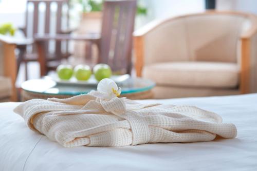 a white towel with a bird on a bed at Azia Resort & Spa in Paphos City