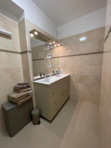 une salle de bain avec un lavabo et un miroir dans l'établissement Luxueux appartement front de mer, à Cannes
