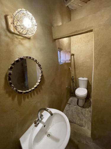 a bathroom with a sink and a mirror and a toilet at Lotus House in siwa oasis