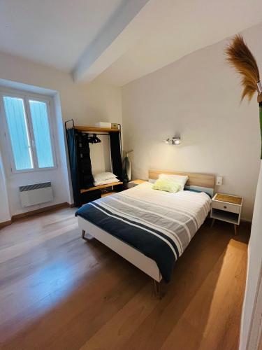 une chambre avec un lit et un grand miroir dans l'établissement Maison de village, à Peyriac-Minervois