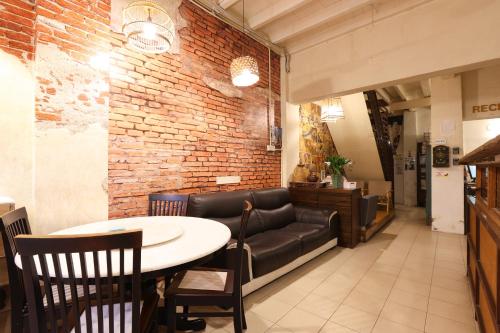 a restaurant with a table and a leather couch at Dou Houz Georgetown in George Town