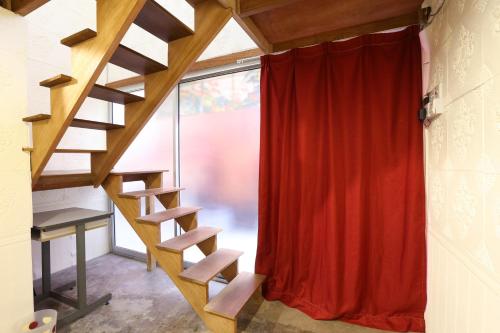 a staircase in a room with a red curtain at Dou Houz Georgetown in George Town