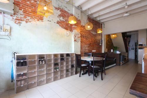 a restaurant with a table and chairs and a brick wall at Dou Houz Georgetown in George Town