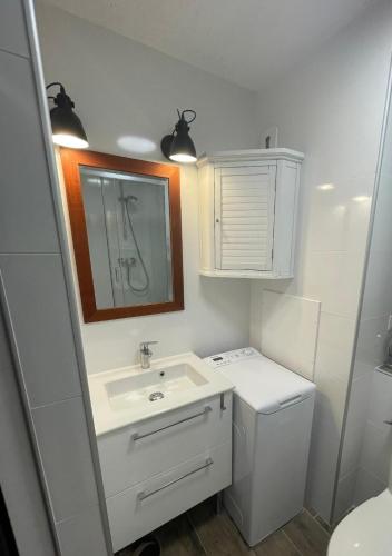 une salle de bain avec un lavabo, des toilettes et un miroir dans l'établissement STUDIO 109 GRANDE TERRASSE, à Bandol