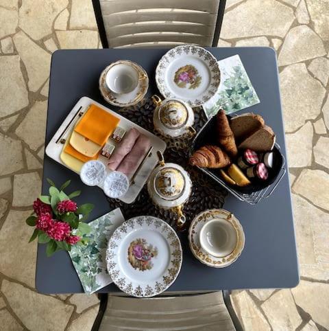 une table bleue avec des assiettes de nourriture et du pain dans l'établissement Les Hauts de Courrech, à Grézels