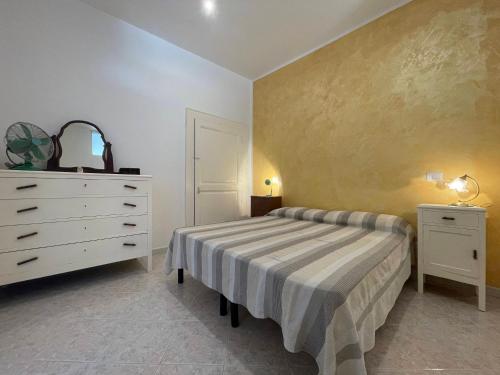 a bedroom with a bed and a white dresser at Medioevo Mare in Pisciotta