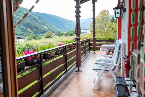 a balcony of a house with chairs and flowers at Residence Obermoarhof - Family Apartments with Pool & Playground in Vandoies