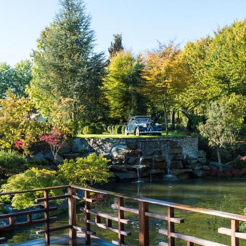 a car parked on a bridge over a pond at Koru Hôtel & Private Wellness in Autre-Église