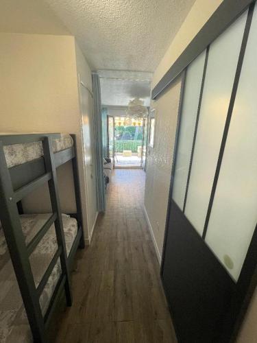 un couloir avec une chambre avec des lits superposés et une porte dans l'établissement STUDIO 109 GRANDE TERRASSE, à Bandol