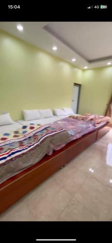 a large bed in a room with chairs and avertisement at Trần Đức hotel in Ba Be