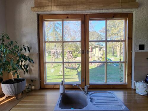 a kitchen with a sink and a large window at Beach house Tolsburg with sauna in Toolse