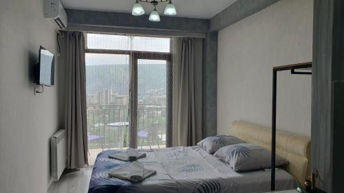 Un dormitorio con una cama y una ventana grande. en GeoFamilyNest, en Tiflis