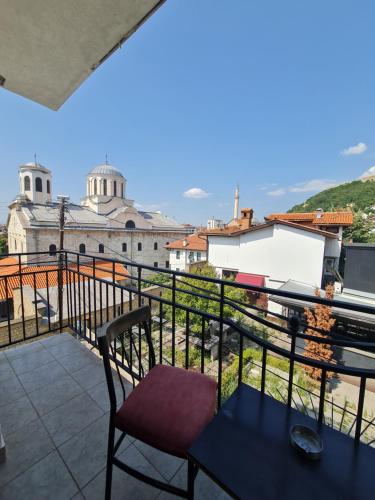 a balcony with a table and a view of a building at Guesthouse Hotel My Home in Prizren