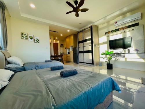 a bedroom with two beds and a flat screen tv at Kuching City Center Riverine Apartment With Balcony and Marvelous View in Kuching