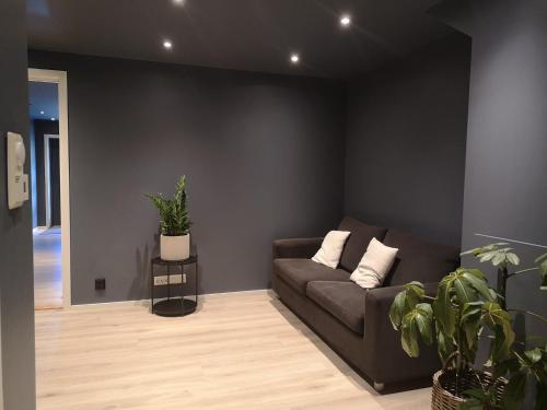 a living room with a couch and some plants at Homestay Storesund in Storasund
