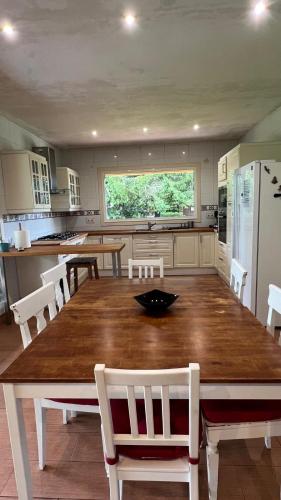 a kitchen with a large wooden table and white chairs at Twin Pines Camino Norte in Arzúa