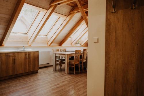 a kitchen and dining room with a table and chairs at Penzion Fořtovna in Častrov