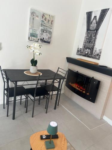 une salle à manger avec une table et une cheminée dans l'établissement Le dunkerquois 3 proximité du centre-ville et plage, à Dunkerque