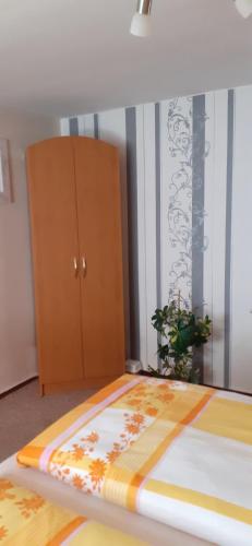 a bedroom with a bed and a wooden cabinet at Ferienhaus Insel Rügen in Glowe