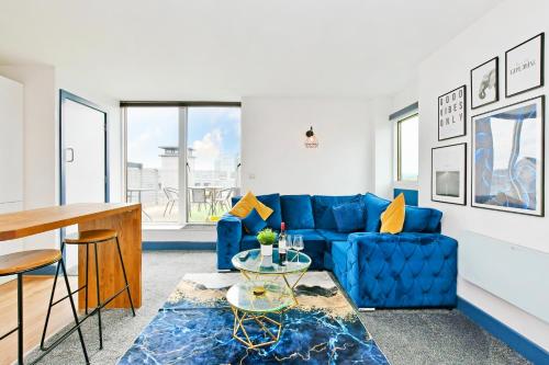 a living room with a blue couch and a table at Sheffield Penthouse with Rooftop Terrace & FREE Parking in Sheffield