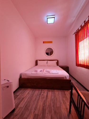 a bedroom with a bed in a room with a window at Guesthouse Hotel My Home in Prizren