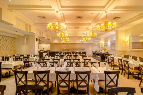 a banquet hall with tables and chairs and chandeliers at Royal Plaza Hotel in Tiberias
