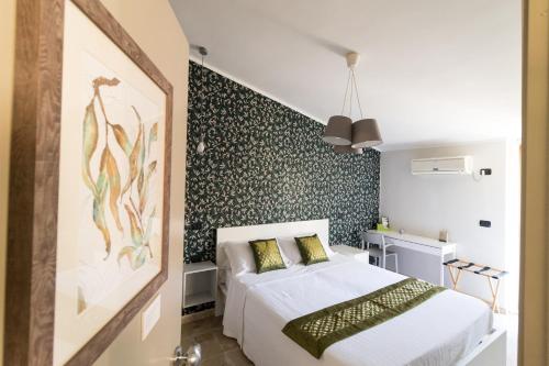a bedroom with a bed and a wall covered in wallpaper at B&B San Carlo in Lamezia Terme