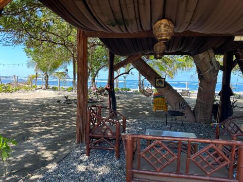 a tent on the beach with a table and chairs at Casa del Árbol Barra la Saladita in La Salada