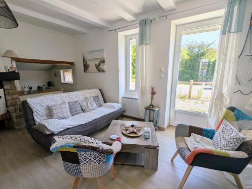 un salon avec un canapé, des chaises et une table dans l'établissement Maison cozy proche des plages - Animaux acceptés !, à La Bernerie-en-Retz