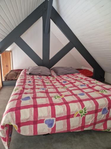 - un lit avec une couette rouge et blanche dans l'établissement Maison 10 min de la plage, à Saint-Gildas-de-Rhuys