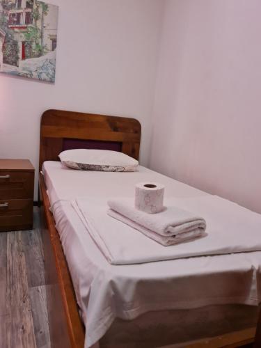 a bed with two towels and a box on it at Guesthouse Hotel My Home in Prizren