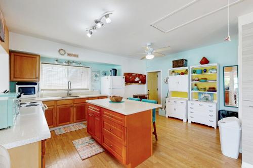 a large kitchen with wooden cabinets and white appliances at Sea Turtle Cottage in Laie