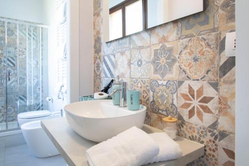 a bathroom with a sink and a toilet at Casa Graziella- appartamenti vacanze in Portacomaro