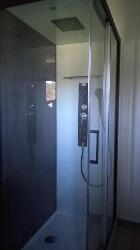 une salle de bain avec une douche avec une porte vitrée dans l'établissement superbe appartement T2 proche de vulcania, à Pontaumur
