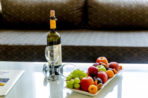 a bottle of wine and a plate of fruit on a table at Royal Plaza Hotel in Tiberias