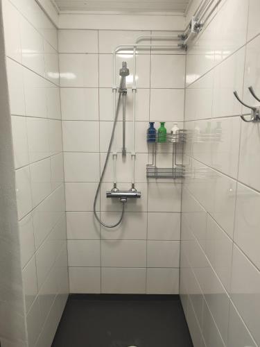a white tiled shower with a hose in a bathroom at Kyyjärvi Camping And Hotels Oy in Kotkaniemi
