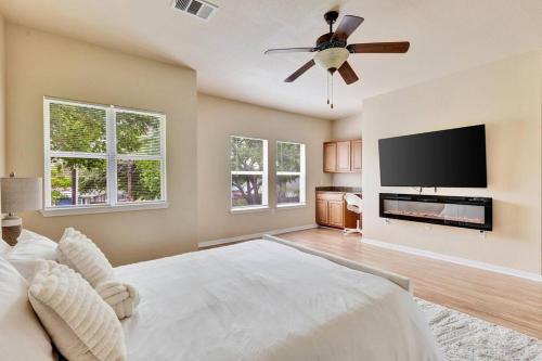 a bedroom with a large bed and a flat screen tv at Spacious Home-Queen Suite-Game room-Movie room in Austin