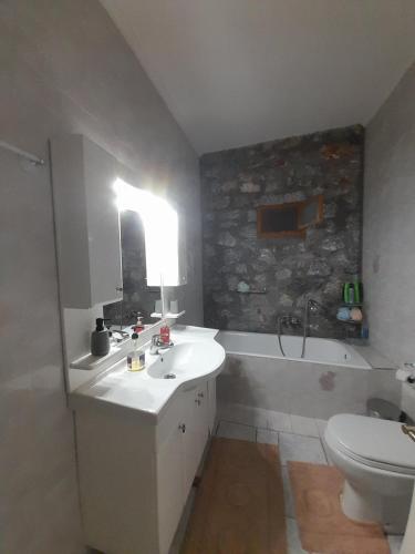 a bathroom with a sink and a tub and a toilet at Terra Mani stone rental apartments in Gerolimenas