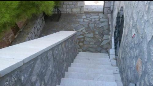 a stairway with a stone wall and a stone staircase at Terra Mani stone rental apartments in Gerolimenas
