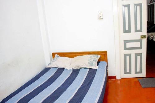 a bedroom with a bed with a blue and white stripes at Ankelipitiya in Kotadeniyawa