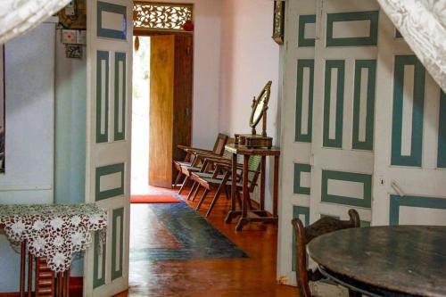 a room with a door with a table and chairs at Ankelipitiya in Kotadeniyawa